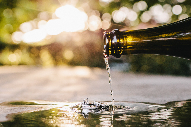 Wine being poured over wedding rings