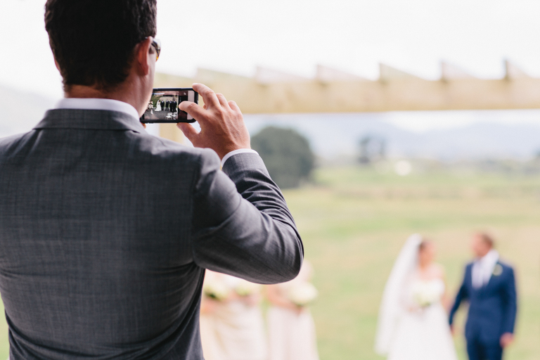 bride and groom captured on a camera phone Te Horo Beach wedding 