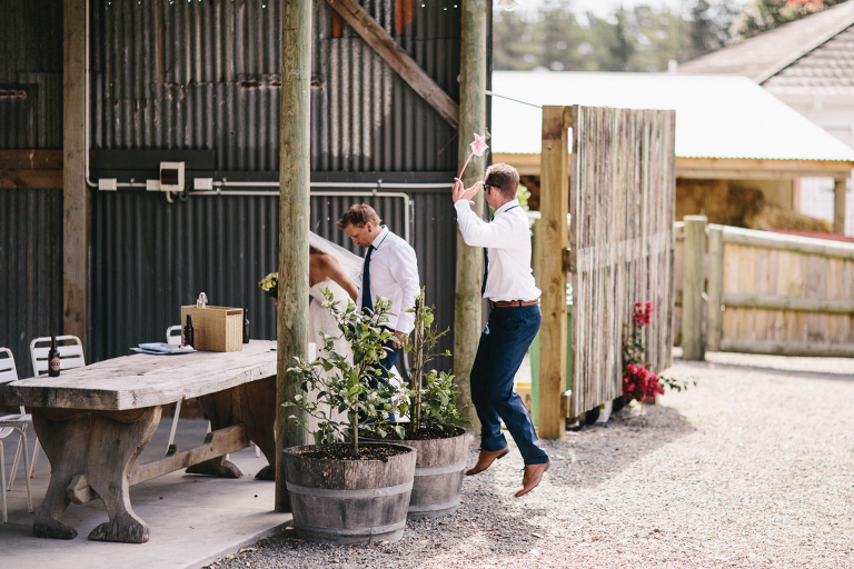Groomsmen jumping natural light rustic outdoor Te Horo Beach wedding 
