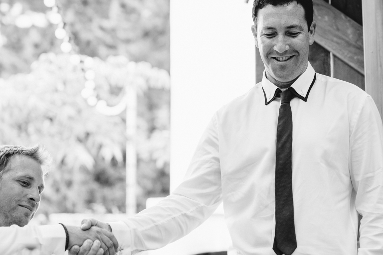Groom and groomsmen handshake outdoor wedding reception Te Horo Beach wedding black and white