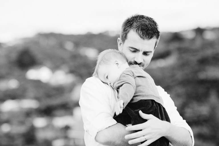 dad with baby boy on chest Wellington in home family photography natural light black and white
