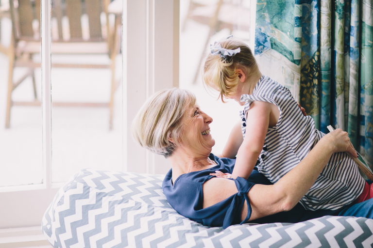 Grandmother and toddler granddaughter laughing and playing on the floor Wellington in home, family photography, natural light 