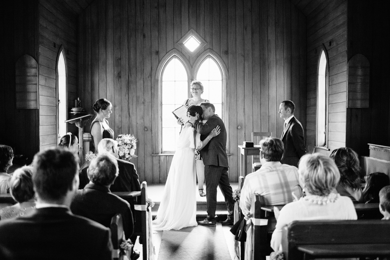 bride and groom kissing at ceremony Burnside Church Martinborough Wedding natural light black and white 