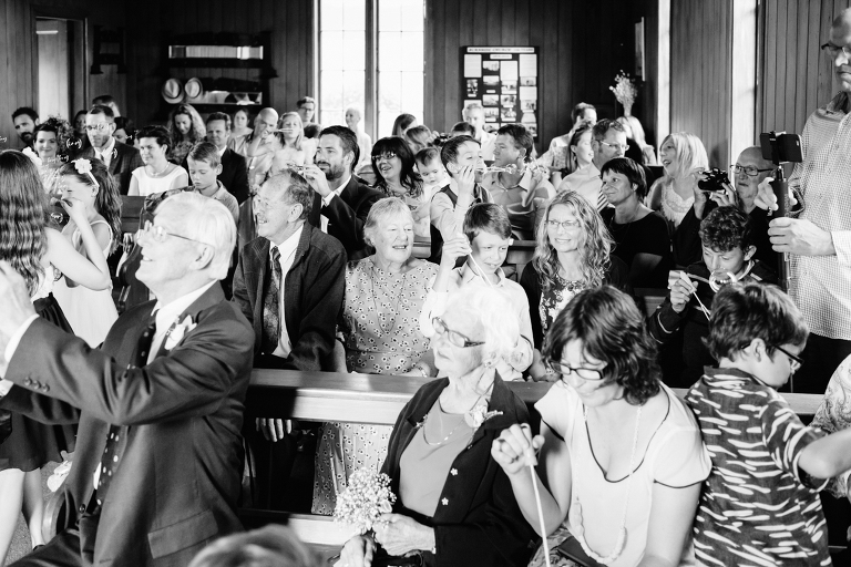 Guests celebrating at ceremony Burnside Church Martinborough Wedding natural light black and white 