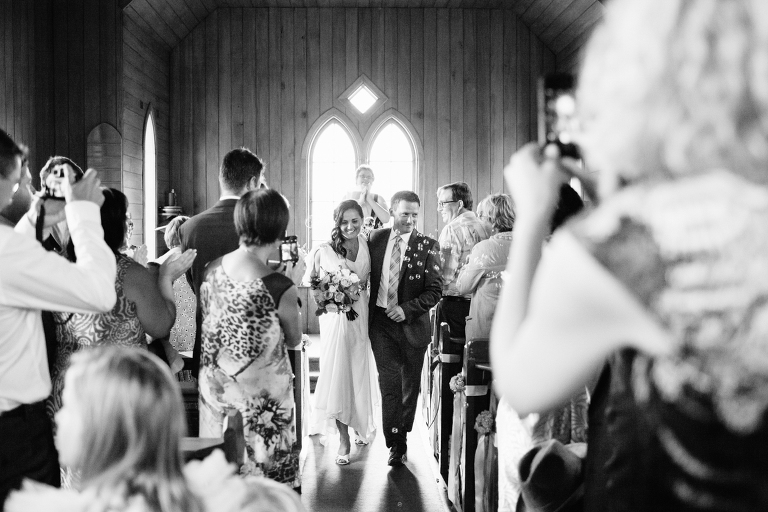 The bride and groom walking down aisle after ceremony Burnside Church Martinborough Wedding natural light black and white
