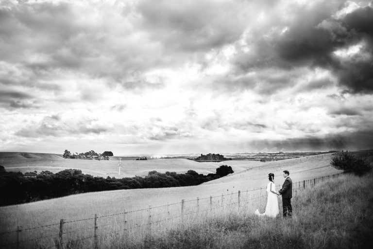 bride and groom holding hands in a rustic field Burnside Church Martinborough Wedding natural light black and white