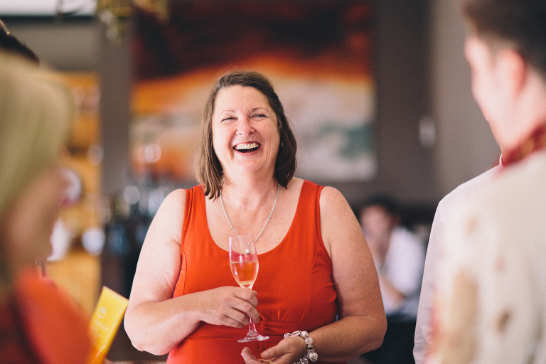 guest laughing with champagne at reception Pauatahanui Inlet Wellington wedding natural light