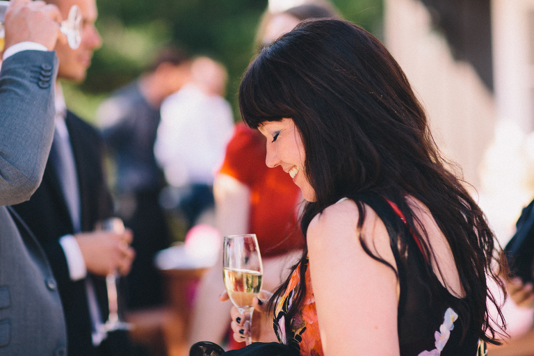 guest smiling with champagne at reception Pauatahanui Inlet Wellington wedding natural light