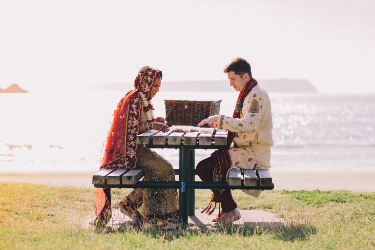 Bride and groom sharing picnic by water Pauatahanui Inlet Wellington wedding natural light