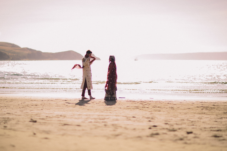 Bride and groom walking by water on beach Pauatahanui Inlet Wellington wedding natural light