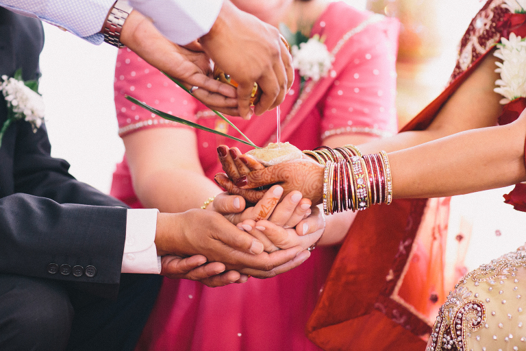 Father and mother with the bride during ceremony, pouring oil into her hands Pauatahanui Inlet Wellington wedding natural light