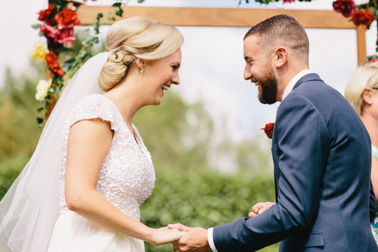 Bride and groom laughing and holding hands ceremony Martinborough Brackenridge Estate wedding natural light 