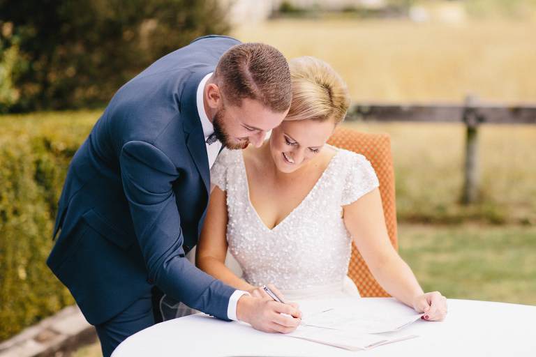 Bride and groom signing marriage license after ceremony Martinborough Brackenridge Estate wedding natural light 