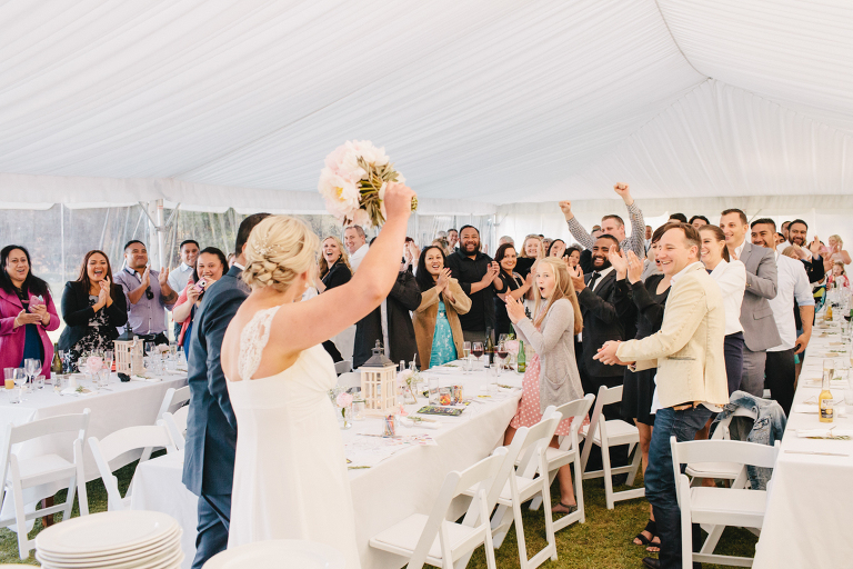 bride and groom entering reception with guests cheering Riversdale Wedding natural light