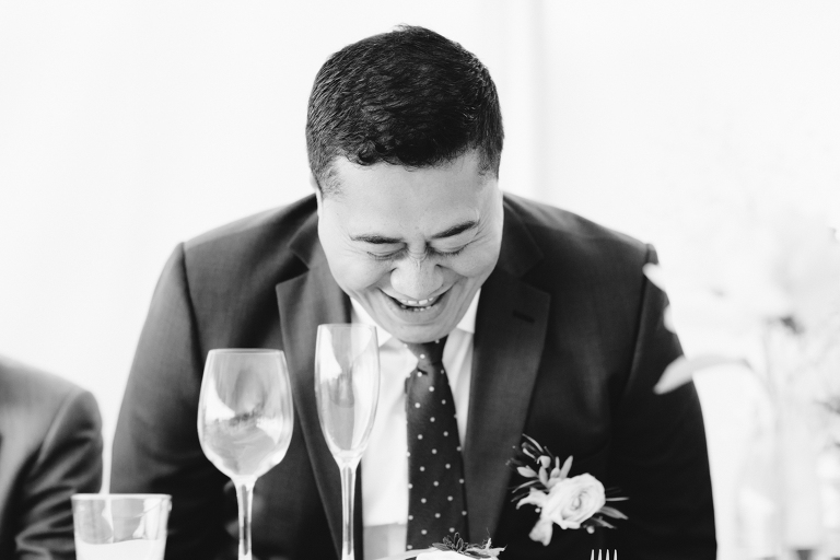 groom laughing at reception Riversdale Wedding natural light black and white