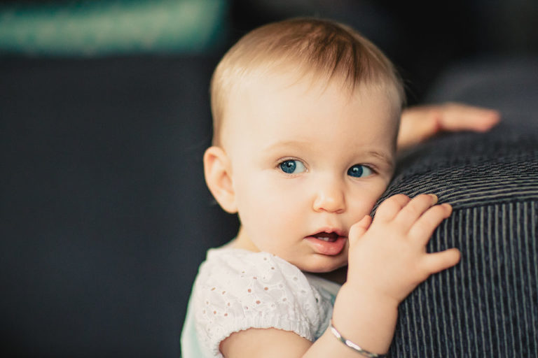 baby girl staring in the distance natural light In-Home Photography First Birthday Party