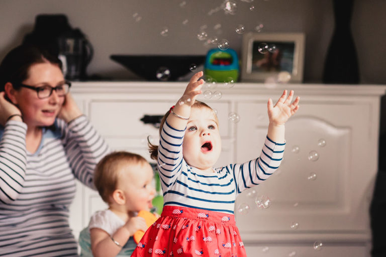 babies playing with bubbles natural light In-Home Photography First Birthday Party