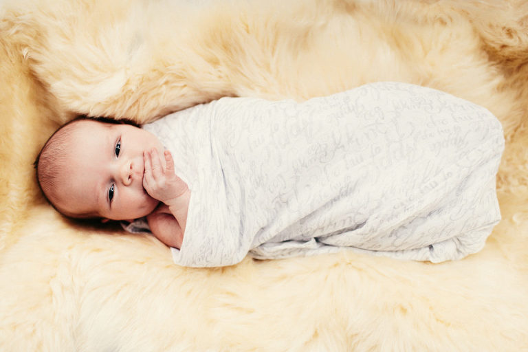 baby girl wrapped in white blanket new born photography in-home Wellington natural light