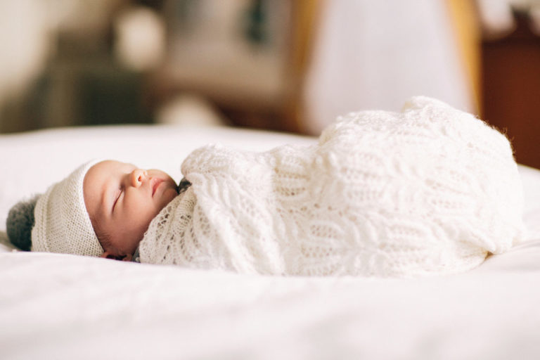 sleeping newborn baby girl wrapped in blanket natural light Wellington newborn photography in-home