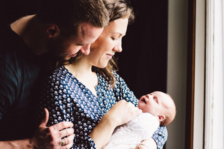 mum and dad gazing at newborn baby girl natural light newborn photography in-home Wellington 