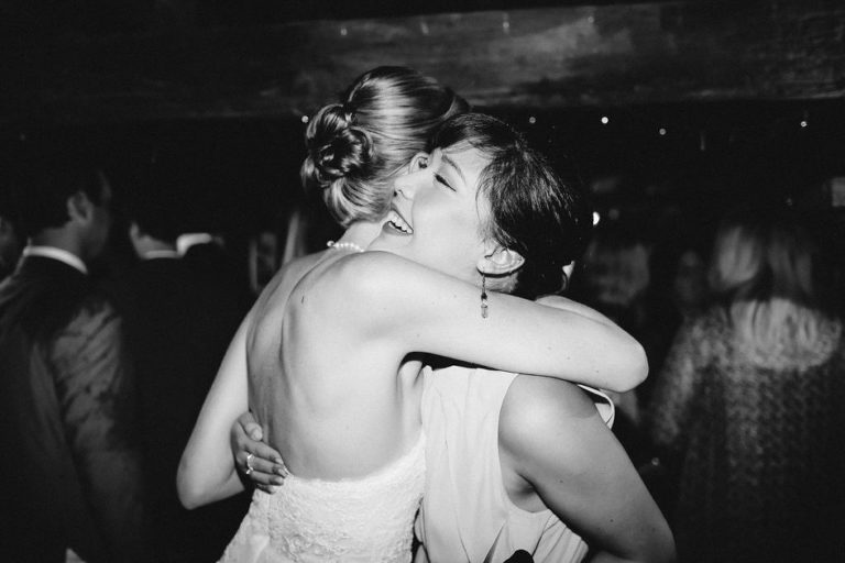 bride hugging guest natural light black and white rainy day wedding Wellington