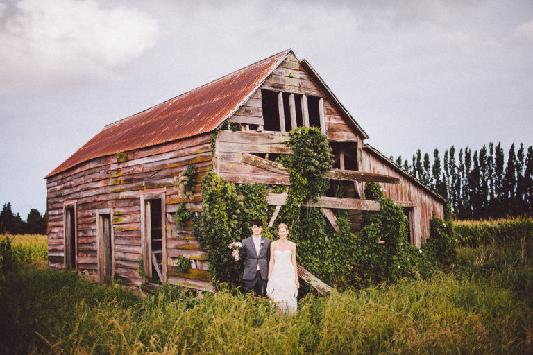 bride and groom standing outside rustic cottage natural light Wellington rainy day wedding