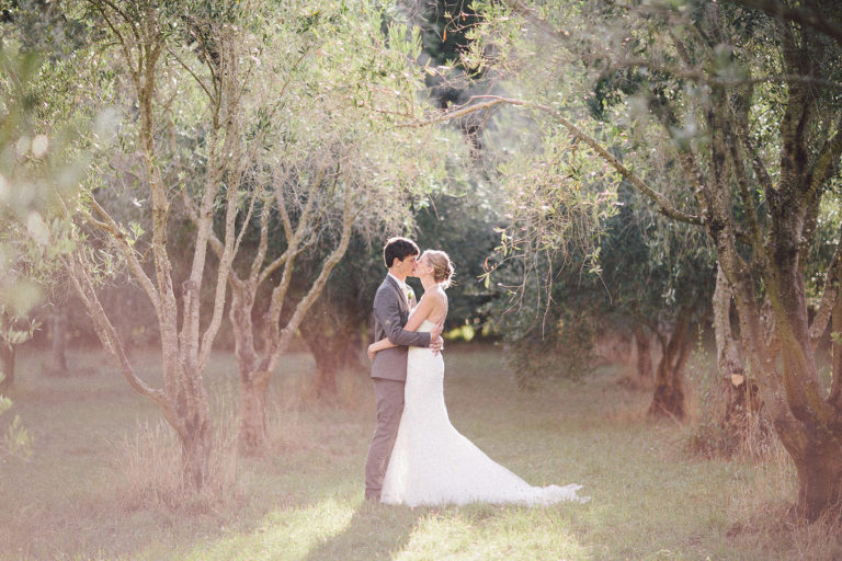 bride and groom kissing under trees in field natural light Wellington rainy wedding