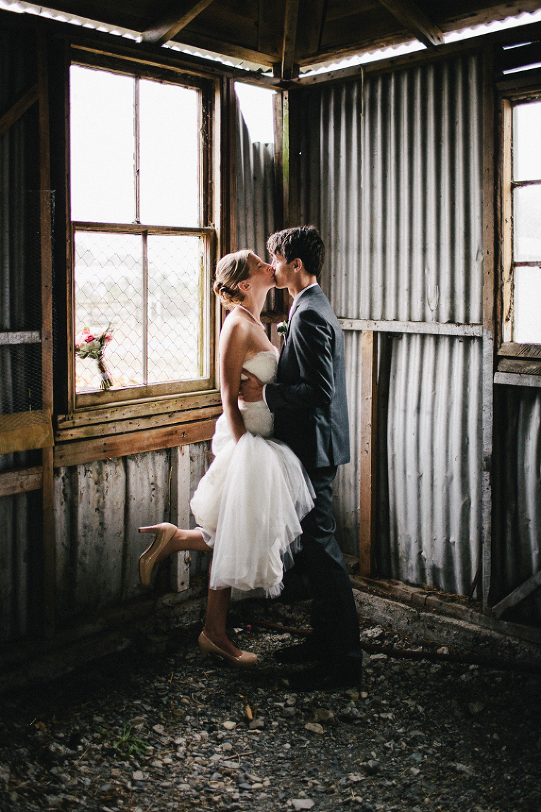 bride and groom embracing in rustic cottage natural light rainy wedding day Wellington