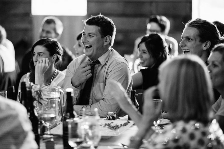 guests laughing at reception natural light black and white Wellington rainy day wedding