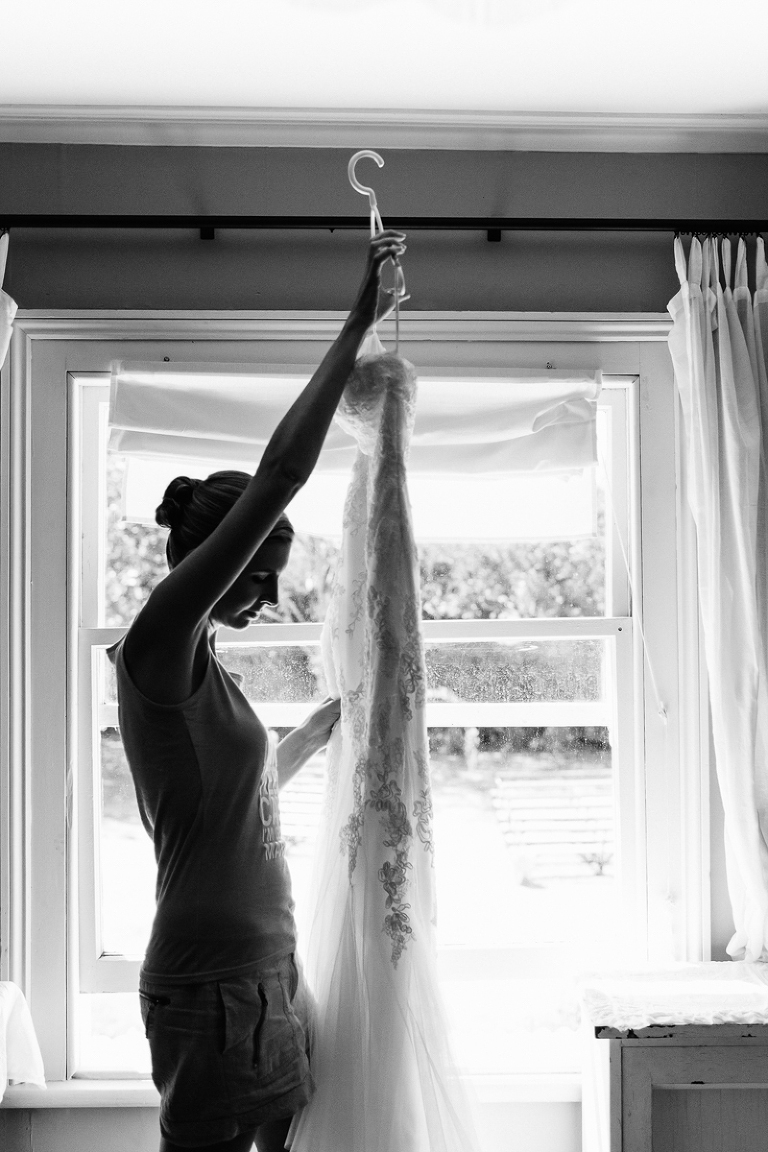 bride holding wedding gown in silhouette black and white natural light Wellington rainy day wedding