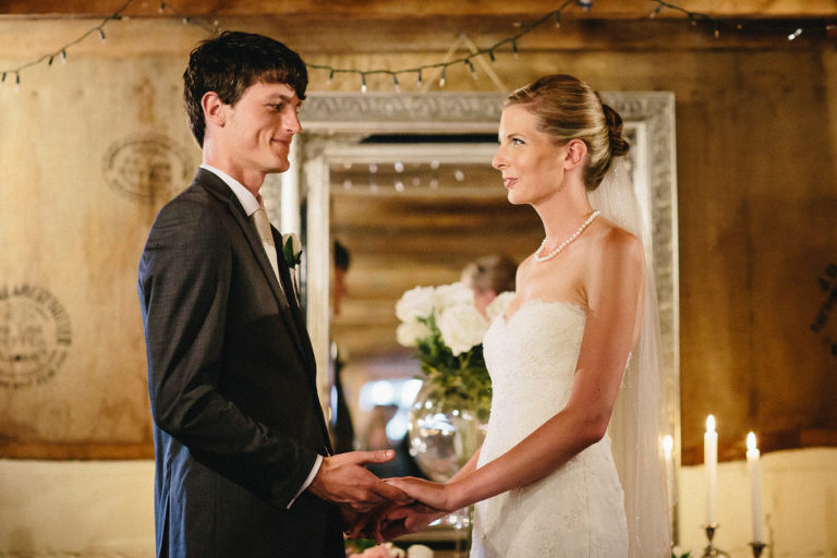 bride and groom holding hands gazing at each other during ceremony natural light Wellington rainy day wedding