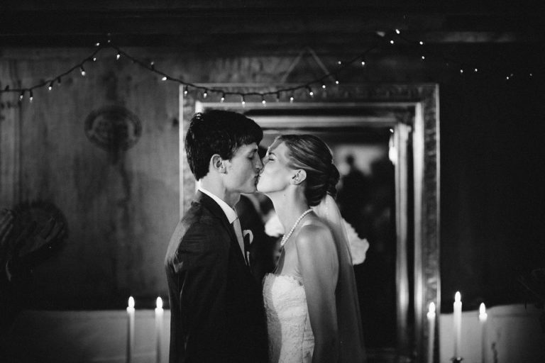 bride and groom kissing during ceremony black and white natural light rainy day wedding Wellington