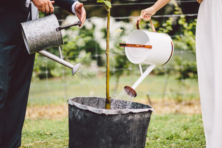 bride and groom holding rustic watering can outdoors Wellington wedding