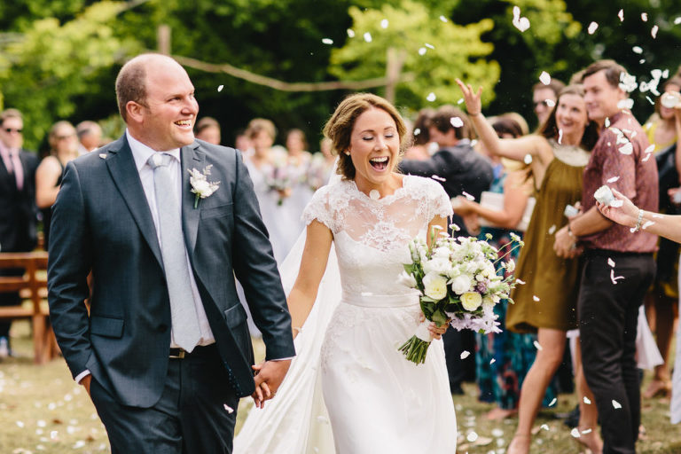 bride and groom smiling walking down aisle hand in hand natural light Wellington wedding
