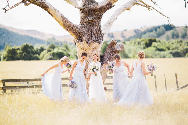 bride and bridesmaids in front of trees in field natural light Wellington wedding
