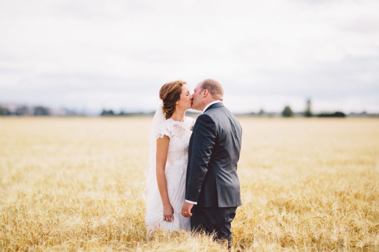 bride and groom kissing in field natural light Wellington wedding