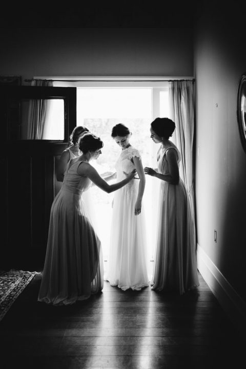 bride and bridesmaids in door way natural light black and white Wellington wedding