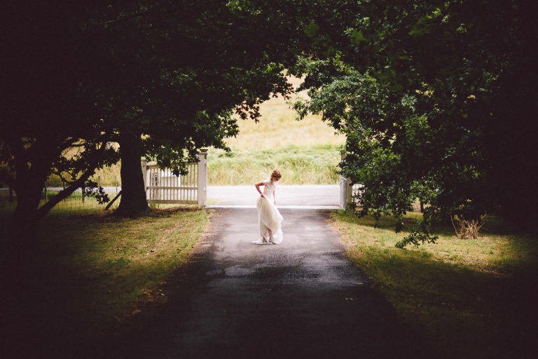 bride on road in woods in wedding gown Wellington wedding natural light