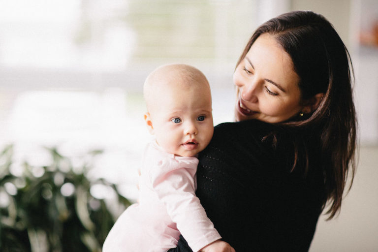 mum holding baby looking at camera natural light Wellington family photography