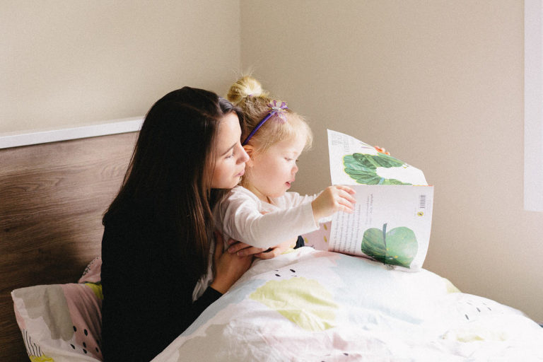 mum with little girl reading story book on bed natural light Wellington family photography